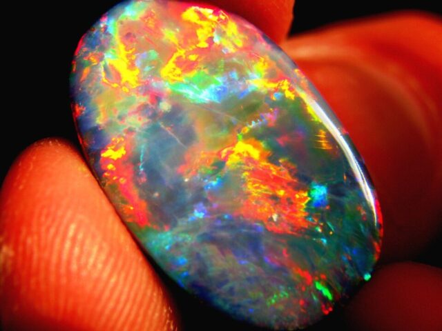 Polished black opal from Lightning Ridge displaying multi-coloured play of colour