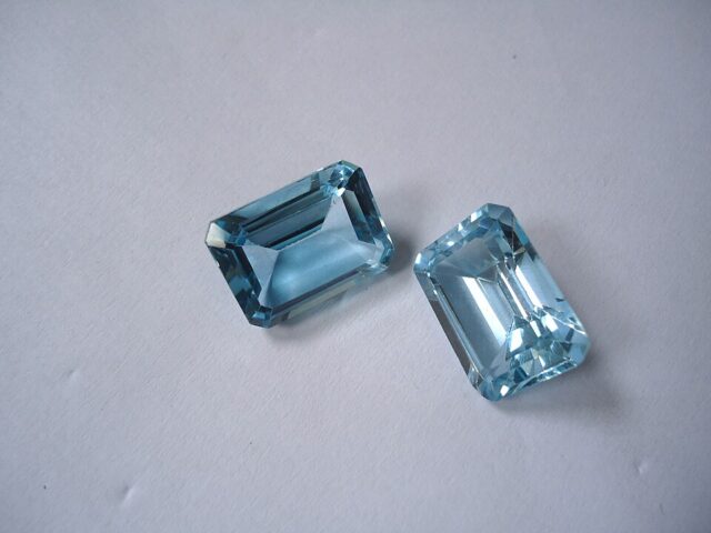 Two natural blue topaz crystals from Brazil showing their pale blue mineral color