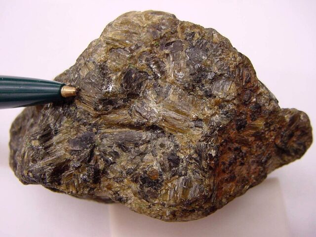Natural hypersthene orthopyroxene mineral specimen with pen for scale