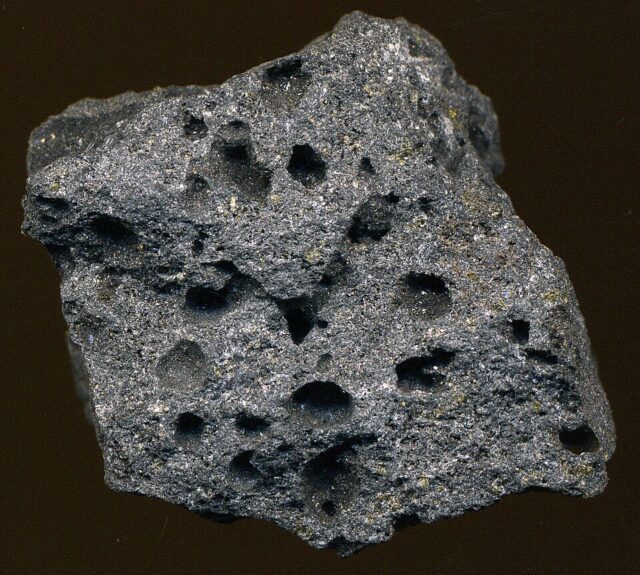 Natural porous vesicular basalt lava rock with visible gas bubble cavities