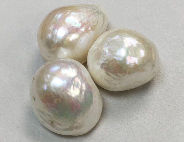 Natural and cultured pearl examples showing white nacreous pearl surfaces